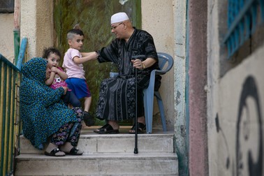 Membrii unei familii de arabi în fața casei din tăbăra de refugiați Aida