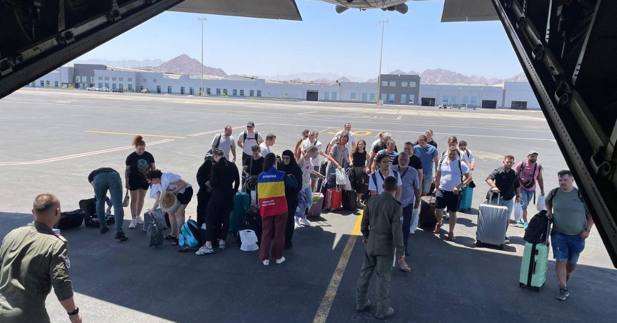 cetățeni români, fotografiați în fața unui avion militar, după ce au fost aduși în România din Iran