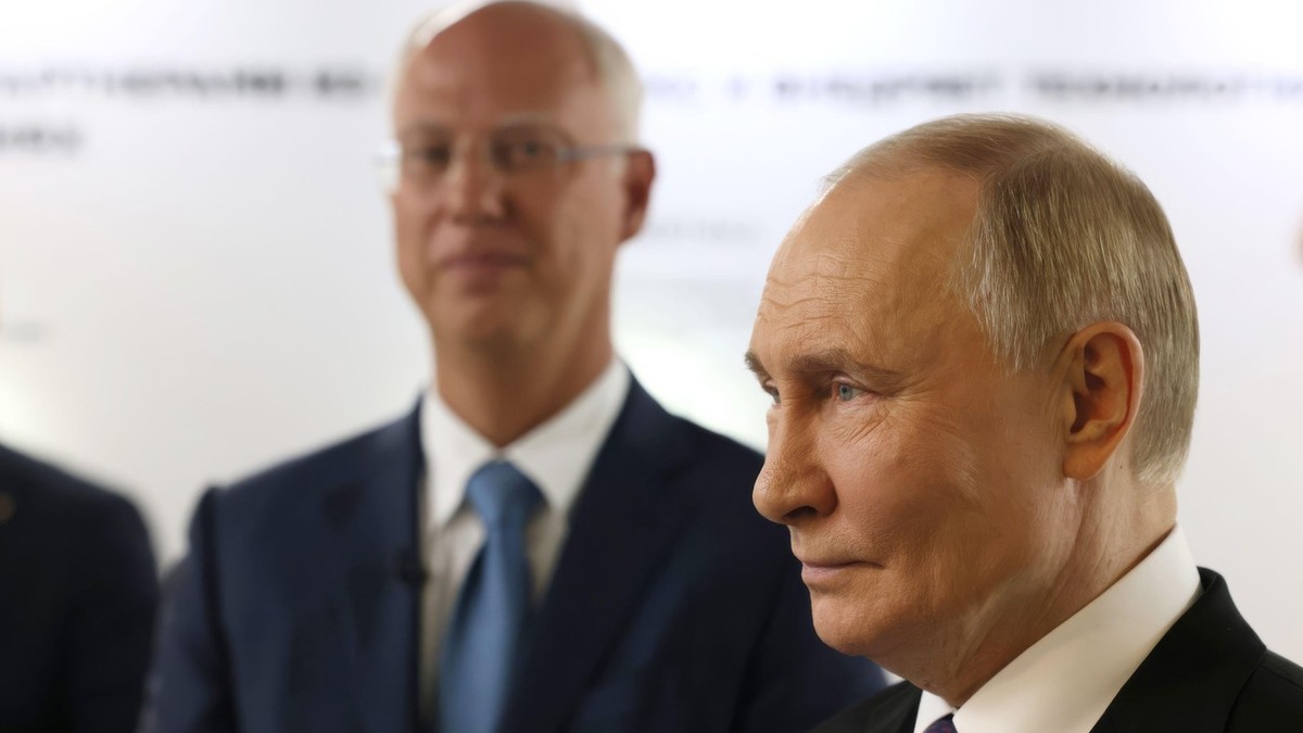 Președintele rus Vladimir Putin, în dreapta, însoțit de directorul general al Fondului rus de investiții directe, Kirill Dmitriev, în stânga, vizitează o expoziție