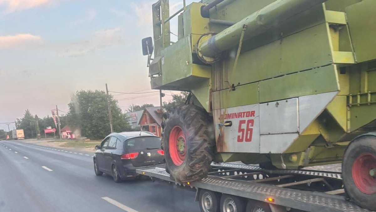 Un autoturism tractează o platformă pe care e o combină Claas de 8,5 tone