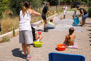 Copiii din Campo Rom di Japigia se joacă împreună alți copii din Bari la un centru familial, sub supravegherea instructorilor