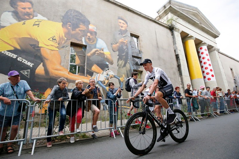 Britanicul Chris Froome trecând pe lângă o pictură murală reprezentându-l pe Bernard Hinault în timpul celei de-a 105 ediții a Turului Franței, 2018 | Foto: EPA