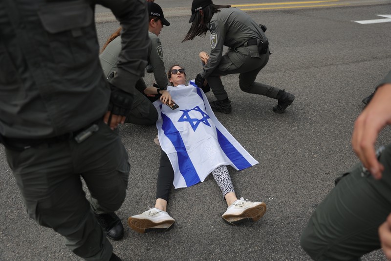 epa10538331 Police detain a protester blocking the Ayalon Highway during a march against the Israeli government's planned reform of the justice system, in Tel Aviv, Israel, 23 March 2023. Nationwide anti-government protests have been held for 12 weeks in a row over the Israeli government's plan to reform the justice system and limit the power of the Supreme Court. EPA-EFE/ABIR SULTAN