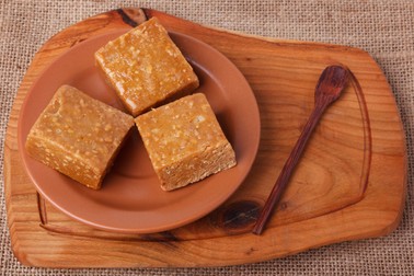 60550442 - pacoca - brazilian candy of ground peanut on brown plate on wooden background. selective focus