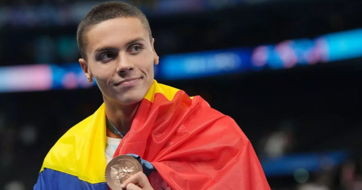 În imagine este ilustrat David Popovici, care poartă tricolorul pe spate