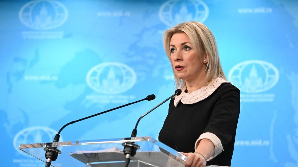 Maria Zaharova, la o conferință de presă, pe un fundal bleu