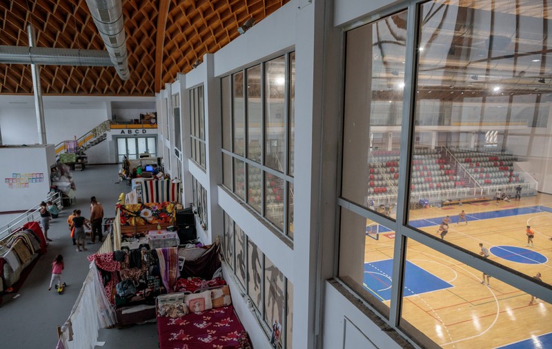De aproape doi ani, zeci de oameni locuiesc într-o sală de sport, în timp ce dincolo de geamuri se joacă meciuri. Primăria le promite că se rezolvă „Săptămâna asta”