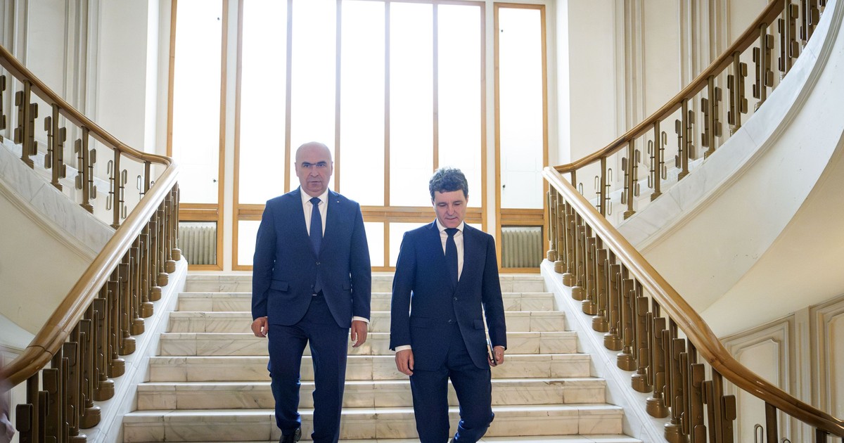Ilie Bolojan (stânga) și Nicușor Dan (dreapta) surprinși în timp ce coboară scările la sediul Curții Constituționale a României, pe 22 mai 2025