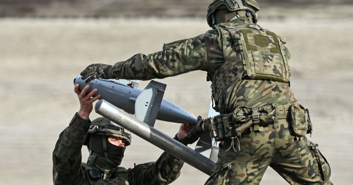 Doi militari îmbrăcați în uniform de camuflaj manevrează un interceptor din sistemul anti-dronă Merops