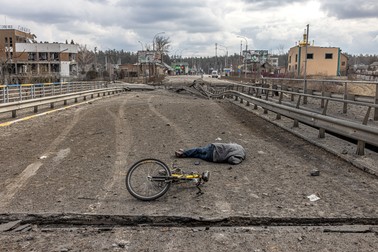 Cadavrul unui bărbat zace lângă o bicicletă pe podul din Irpin, 7 martie 2022. Foto: EPA