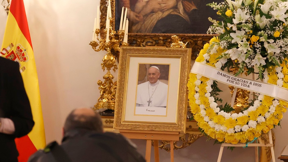 Un tablou al Papei Francisc, alături de o coroană din flori albe și galbene, la Palatul Apostolic