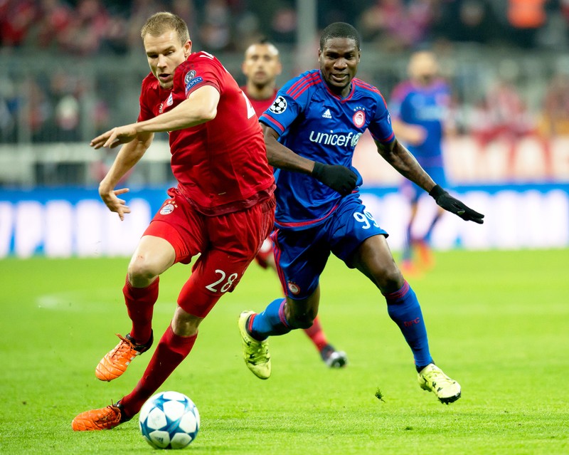 epa05040370 Bayern Munich's Holger Badstuber (L) in action against Olympiacos Piraeus' Ideye Brown (R) during the UEFA Champions League Group F soccer match between Bayern Munich and Olympiacos Piraeus in Munich, Germany, 24 November 2015. EPA/SVEN HOPPE