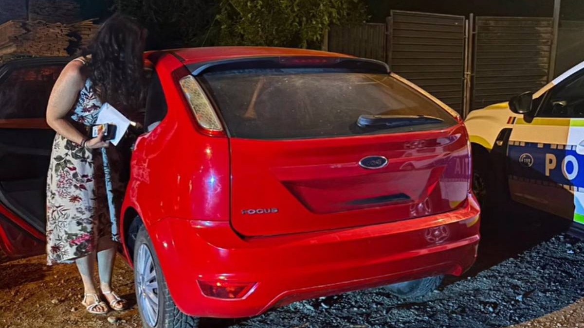 femeie cu o rochie cu flori langa o masina ford rosie, dupa ce a fost prinsa fara permis, noaptea