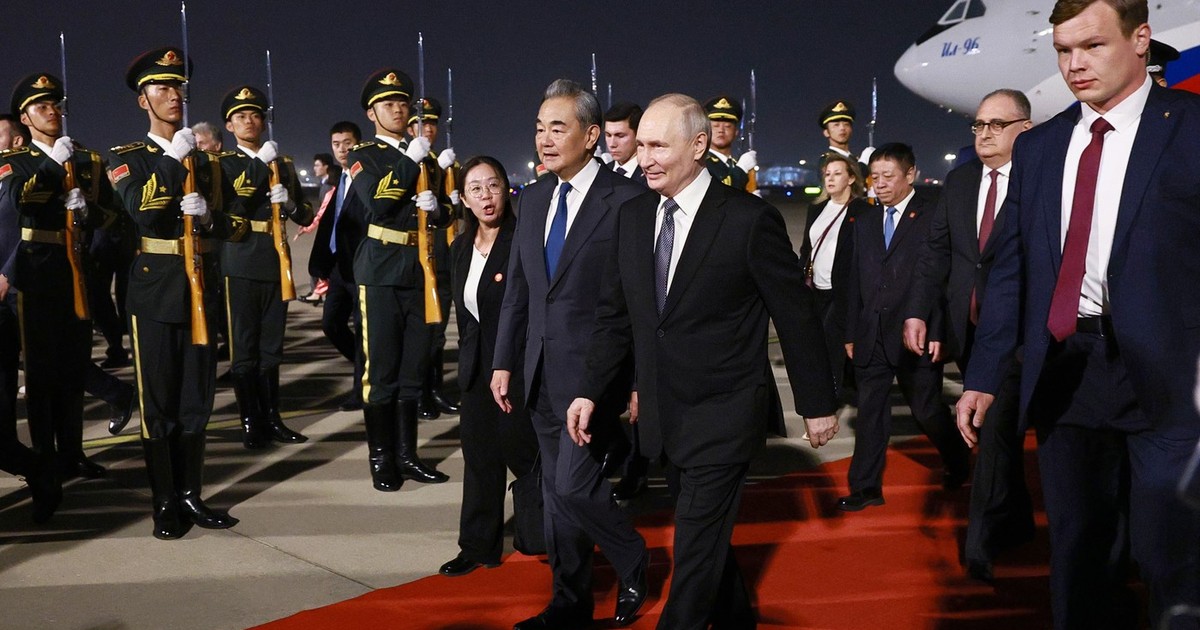 Vladimir Putin, cu zâmbetul pe buze după sosirea la Beijing, unde a fost întâmpinat de ministrul de Externe Wang Yi Foto: Profimedia