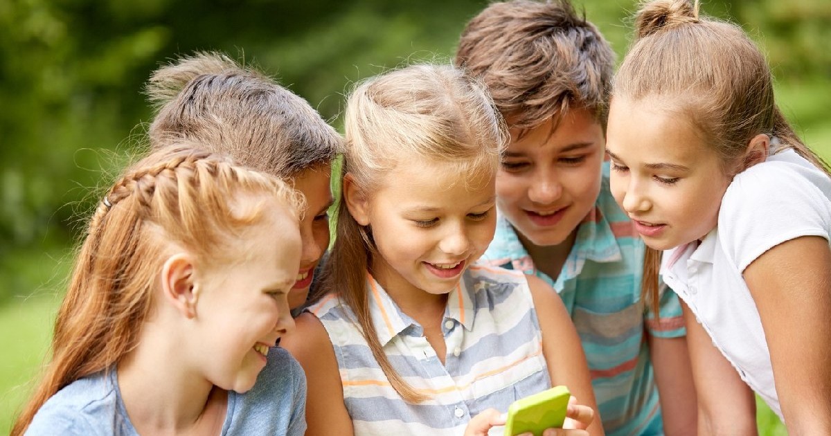 mai mulți copii se uită la un smartphone