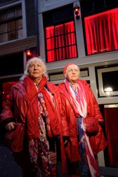 TO GO WITH AFP STORY BY JAN HENNOP Prostitutes Martine (R) and Louise (L) Fokkens, 70, walk around the red-light-district of Amsterdam on November 15, 2012, the Netherlands. Twins Martine and Louise Fokkens, nicknamed the 'Queens of the wallen', are Amsterdam's oldest prostitutes, having worked for fifty years in the city's red-light-district, and they have wrote two books about their experiences.,Image: 147295978, License: Rights-managed, Restrictions: TO GO WITH AFP STORY BY JAN HENNOP, Model Release: no