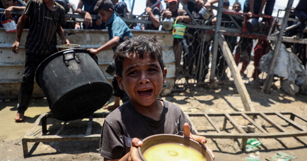 Imagine cu un copil care ține în mâini un bol cu mâncare, în Gaza.