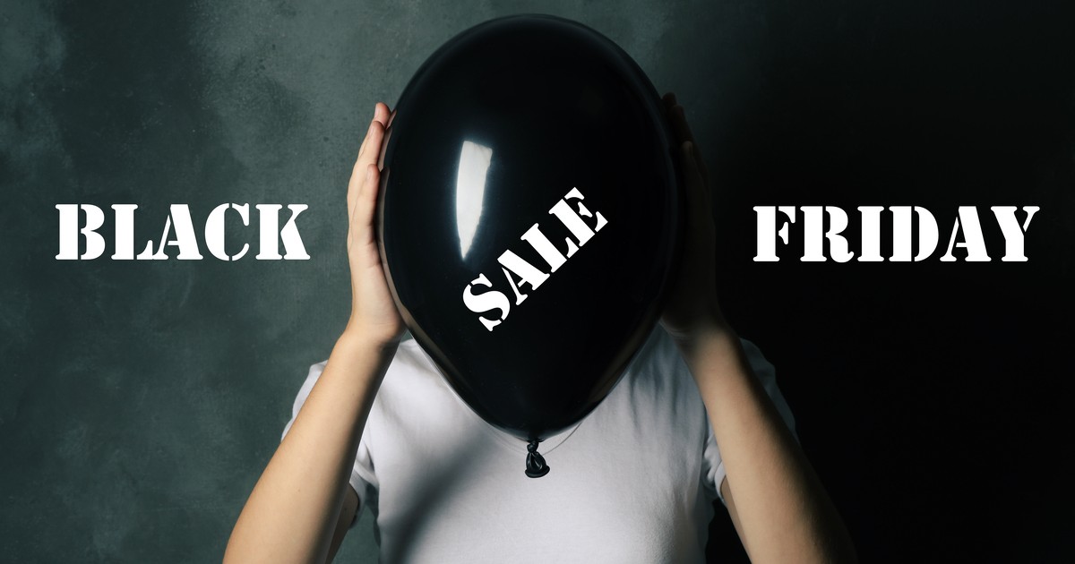 Black Friday, femeie care ține în mână un balon negru pe gare scrie Sale