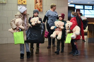 Copiii țin în mână jucării în timpul unui eveniment dedicat copiilor orfani din autoproclamata Republică Populară Luhansk. Micuții au fost transferați în grija unor părinți adoptivi, pe aeroportul Tolmachevo din Novosibirsk, Rusia | Foto: Profimedia