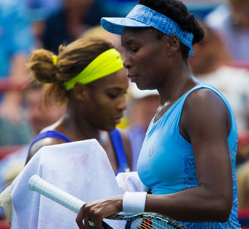 epa04347665 Venus Williams (R) of the US walks past Serena Williams of the US during their semi-final match at the Rogers Cup women tennis tournament in Montreal, Canada, 09 August 2014. EPA/ANDRE PICHETTE