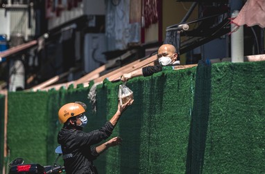 Un livrator aduce mâncare unui locuitor carantinat Covid-19, în Shanghai, pe 5 mai 2022. | Foto: Profimedia