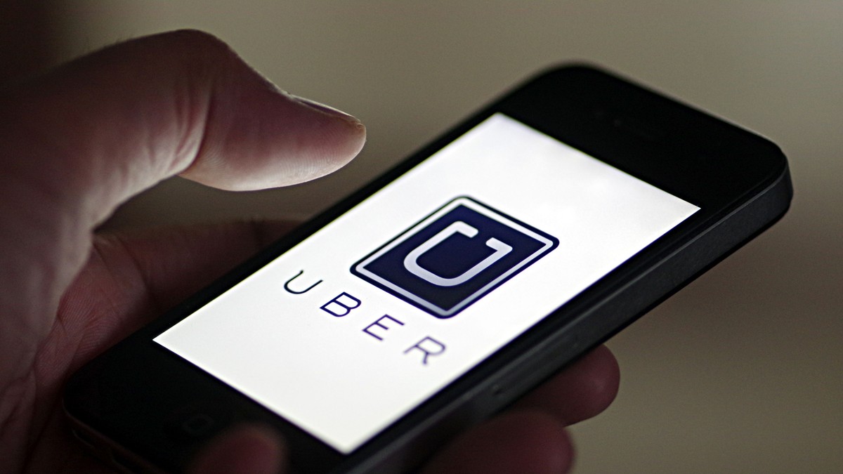 Uber, acuzată că a impus o taxă ascunsă. Aplicația Uber, deschisă pe un iPhone