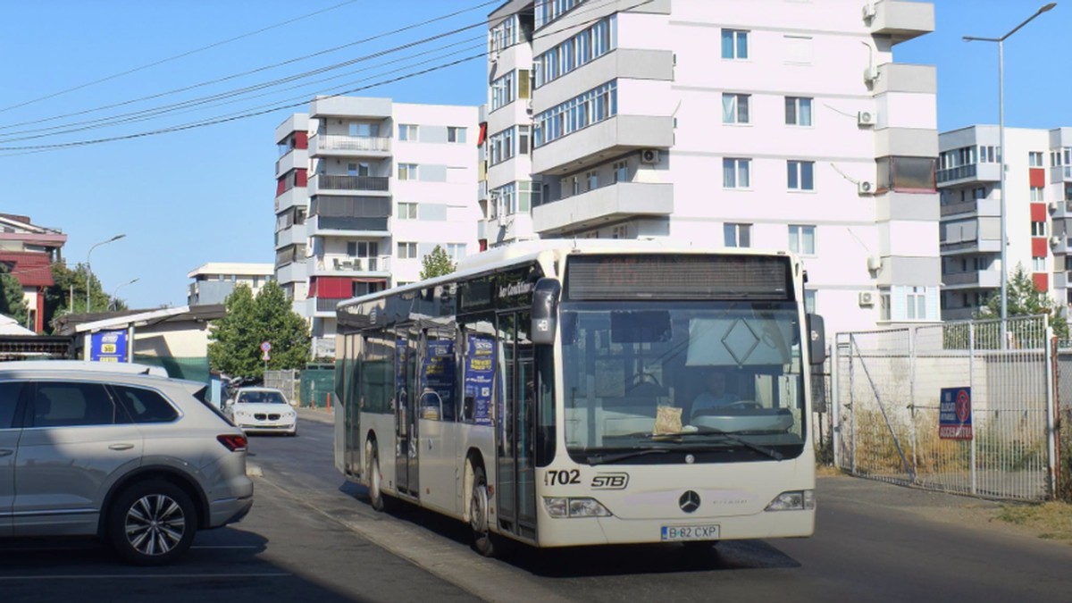 Un autobuz STB alb circulă pe o stradă din București