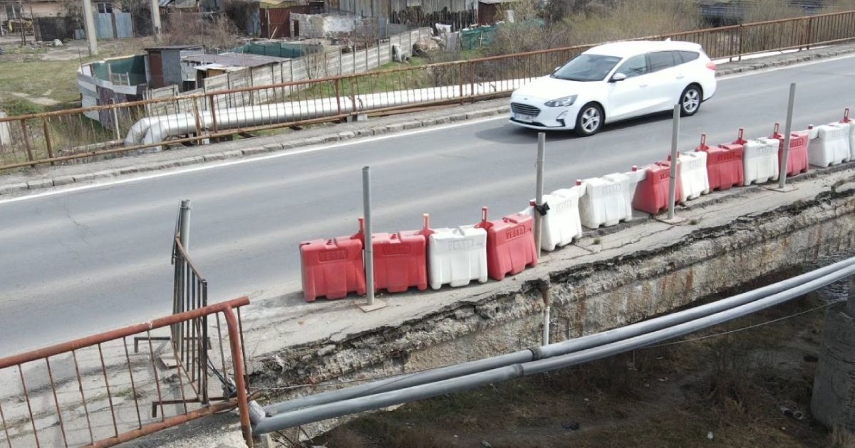 Podul de pe Drumul CET-ului din Brașov, în stare critică, fără balustradă, și o mașină albă care îl traversează