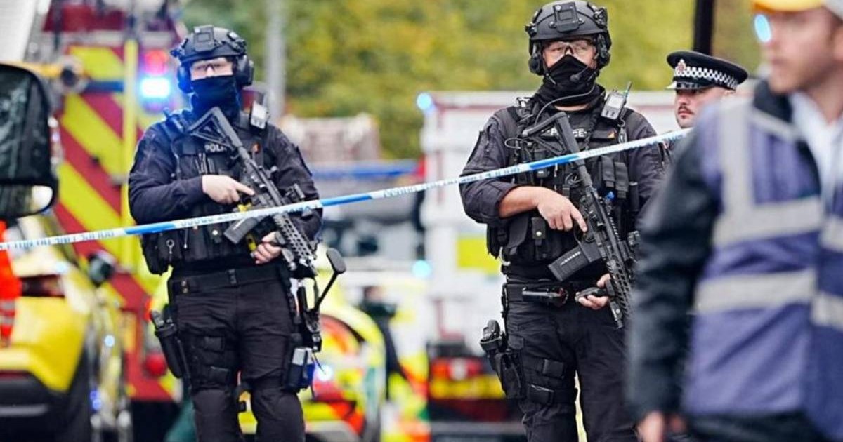 Doi mascati inarmati, in strada, in jurul lor ambulante si politie, dupa un atac la o sinagoga in Manchester, Marea Britanie. 2 octombrie 2025
