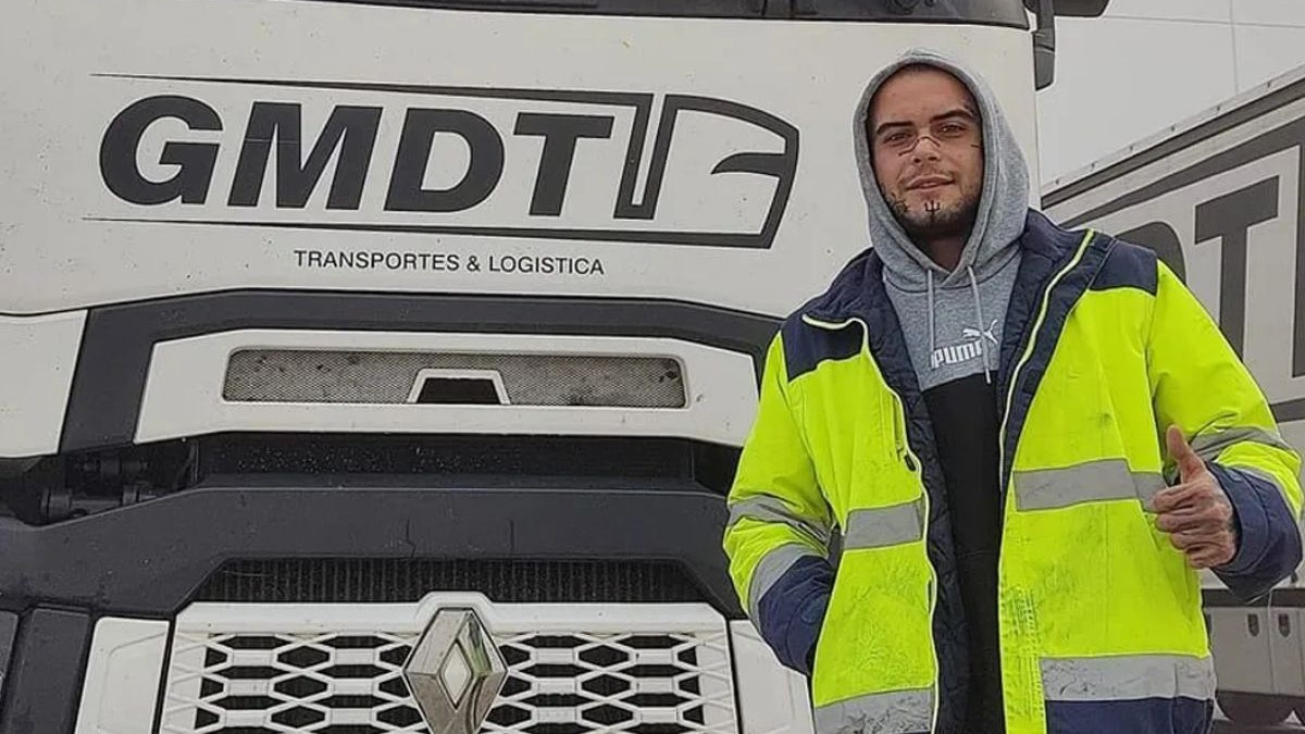 Cristian Stratan, îmbrăcat cu o geacă de lucru, de culoare verde, în fața unui camion de culoare albă