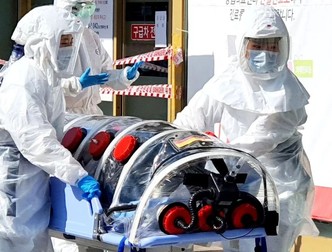 Medici transportând un pacient infectat cu coronavirus