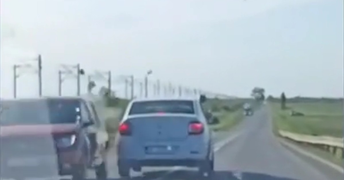 două mașini pe șosea., una lângă alta. cea albă a pătruns pe contrasens