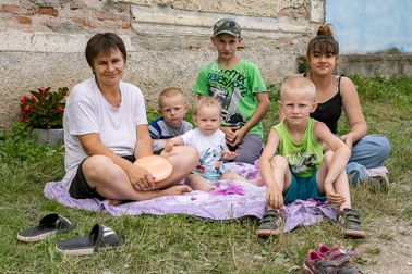 Cei cinci copii din Poieniţa şi mama lor se odihnesc pe o pătură, la umbră