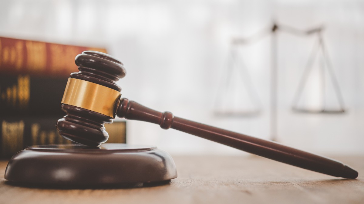 Ciocanul judecătorului aflat pe o masă de lemn