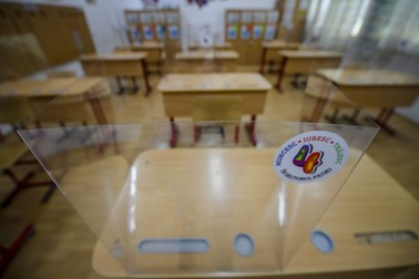 Imagine cu o foaie de plexiglas montată pe o bancă, ca măsură de protecție, într-o sală de clasă. Foto Hepta