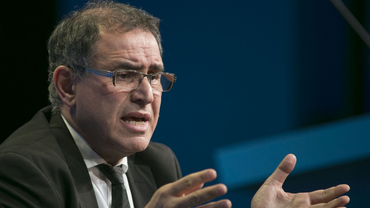 Nouriel Roubini avertizează asupra unei viitoare crize economice. „Întrebarea nu este dacă, ci când‟. Roubini la costum și cu ochelari, gesticulând cu mâinile