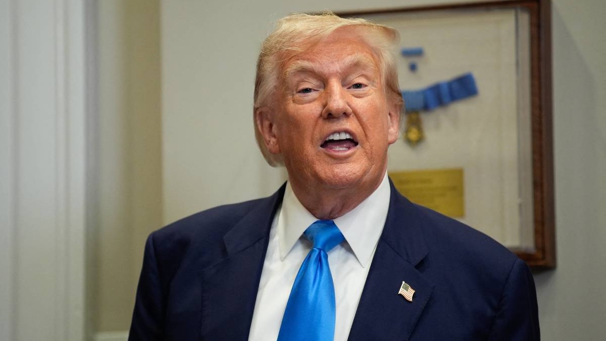 Președintele american Donald Trump, în Biroul Oval, râde în fața camerei purtând un costum albastru