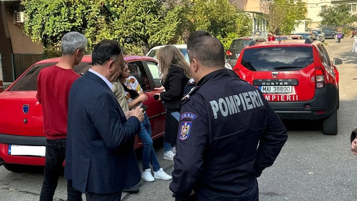 Unele dintre persoanele evacuate din blocul din Mioveni, în timp ce discută cu autoritățile prezente la fața locului, pompierii au intervenit de urgență