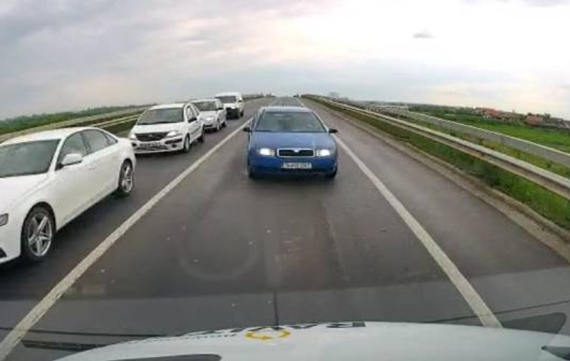 Momentul în care un șofer intră pe contrasens să depășească coloana și intră frontal într-un microbuz - VIDEO