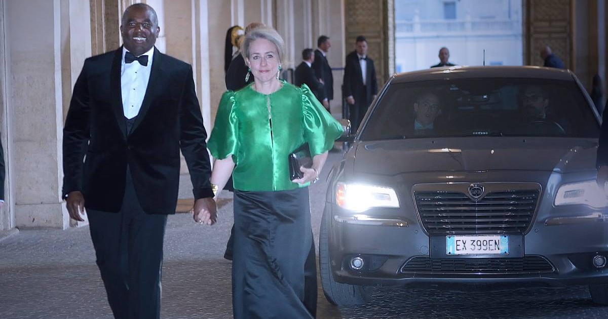 David Lammy, actual ministru britanic de externe, alături de soția sa, artista Nicola Green, în timp ce merg ținându-se de mână, îmbrăcați elegant, la un eveniment oficial.