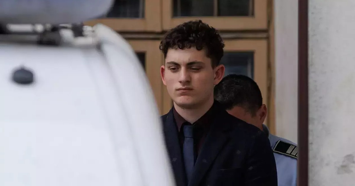 Vlad Pascu, in costum negru, cu cravata, iese din instanta insotit de un politist