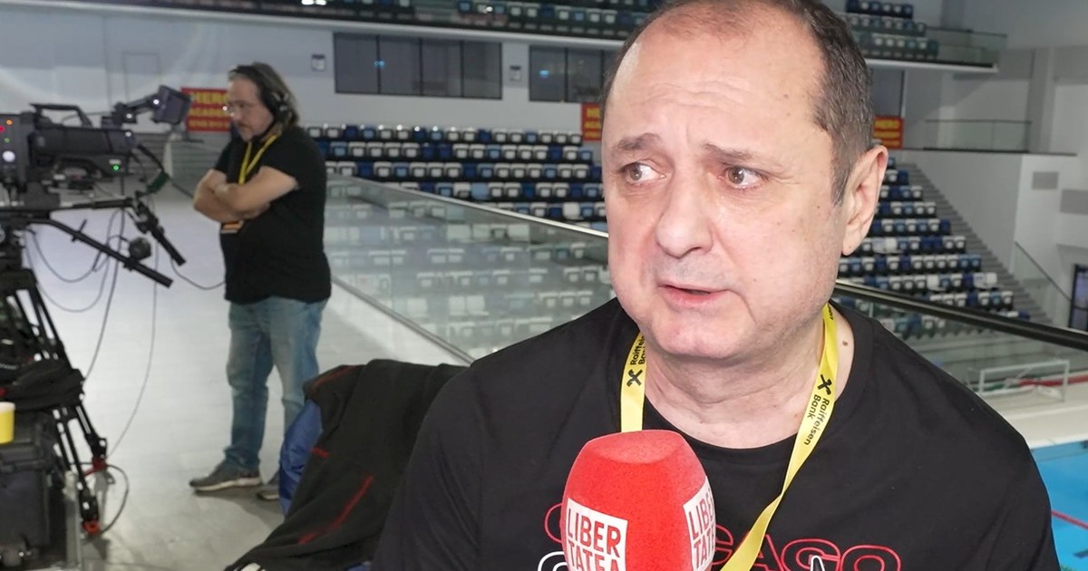 emil hossu longin, intr-un tricou negru, afat deasupra bazinului de inot, vorbeste la microfonul Libertatea