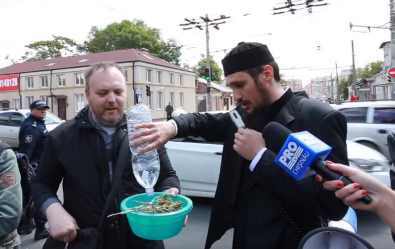 Un preot a stropit o lesbiană cu agheasmă în direct la o emisiune din Republica Moldova. A fost condamnat în instanță pentru gestul său