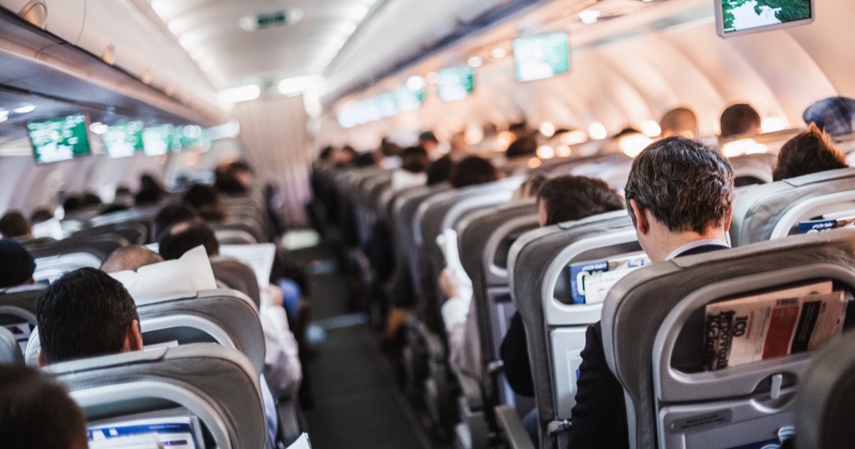 Pasagerii unui avion, stând fiecare pe locul lui, în timpul decolării