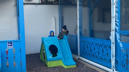 Doi dintre copiii refugiați, jucându-se fără griji în curtea pensiunii Casa Filip