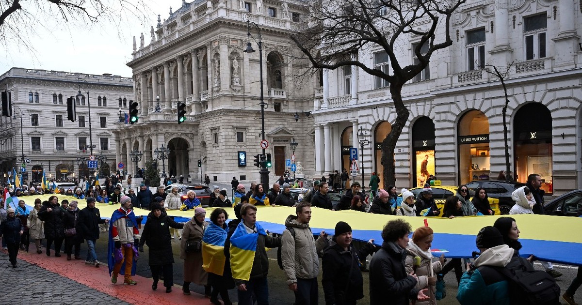 Oamenii poartă un steag ucrainean uriaș în fața Ambasadei Rusiei în cadrul unui marș de solidaritate în sprijinul Ucrainei, organizat la Budapesta, duminică, 22 februarie 2026
