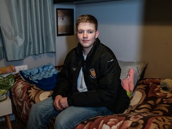 Andrei, în camera sa din Rugby, UK, purtând geaca cu însemnele Colegiului Oriel