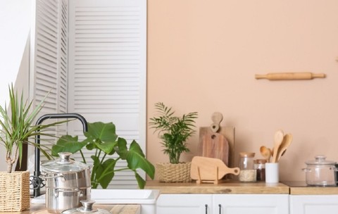 Interior modern de bucătărie cu blat din lemn și ustensile de bucătărie pentru prepararea mâncărurilor, într-un apartament confortabil