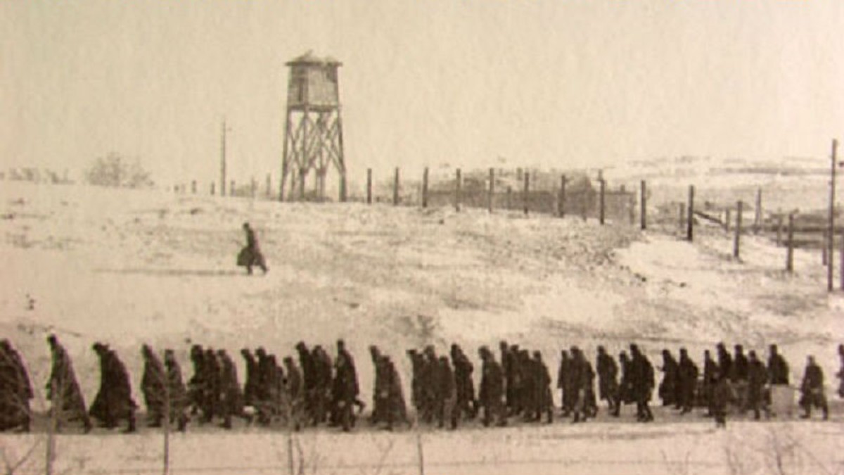 Ce s-a întâmplat azi, 21 iunie. Fotografie alb-negru cu ostatici mergând prin zăpadă. În fundal, este un foișor de observație, îngrădir cu sârmă ghimpată