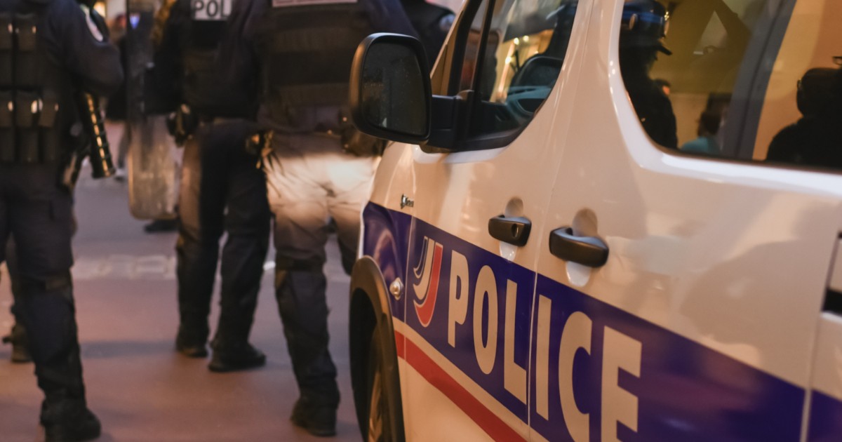Polițiști care stau lângă o mașină de poliție, în Franța.